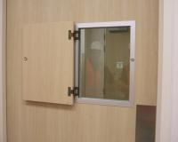 Formica faced hospital door set with vision panel and hinged privacy flap.